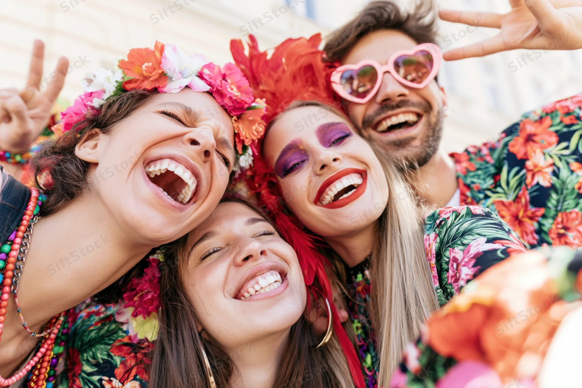 Four friends laughing and taking a selfie at a street carnival