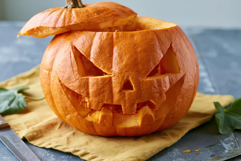 Carved pumpkin with jagged face on a cloth on a table