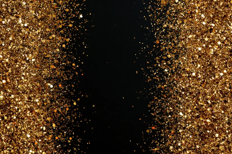 Gold glitter particles densely scattered along both left and right sides against a black background