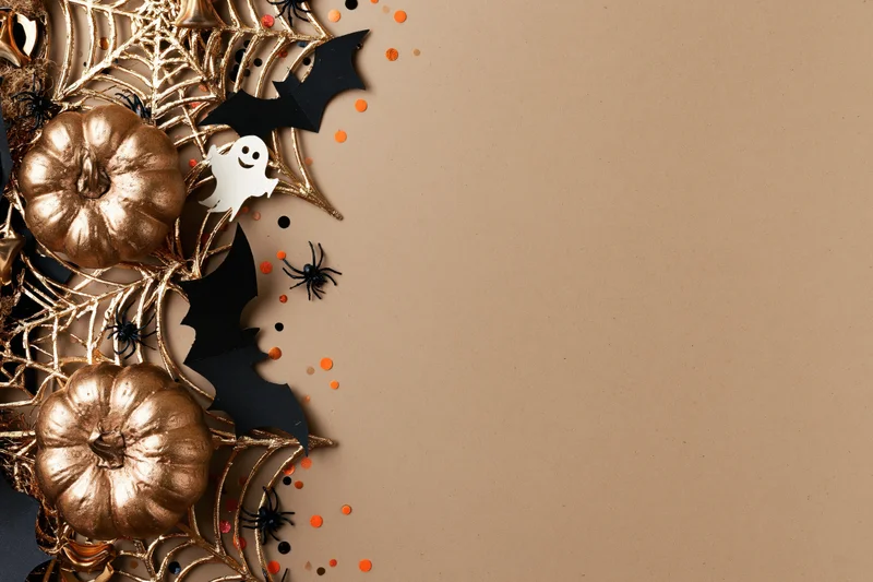 Halloween decorations arranged in corner on beige surface with copyspace