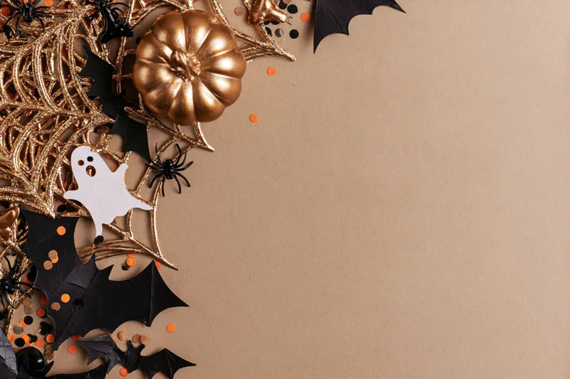 Halloween decorations arranged in corner on beige surface with copyspace