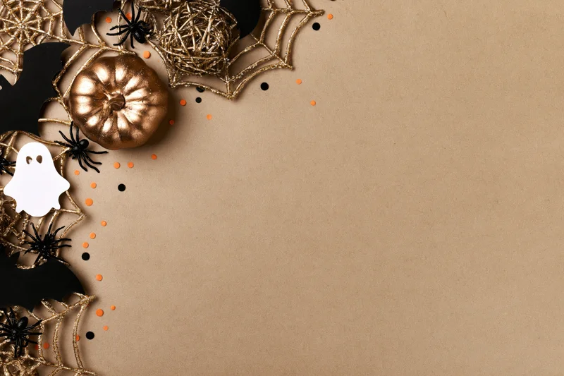 Halloween decorations arranged in corner on brown surface with copyspace