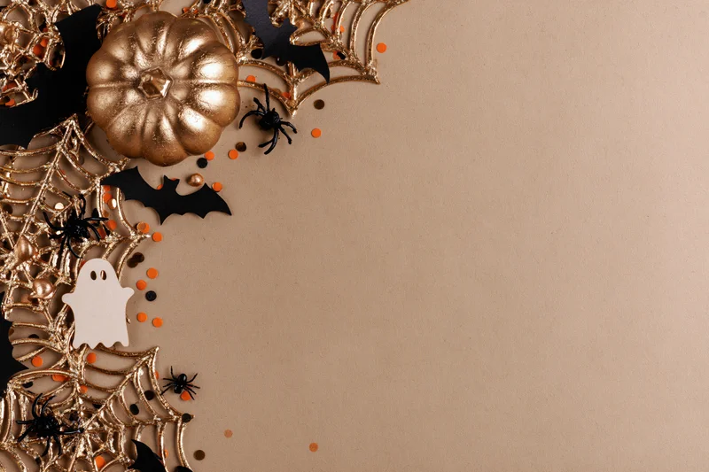 Halloween decorations arranged in flat lay on beige surface with copyspace
