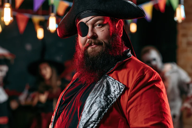 Heavyset man in pirate costume with red beard and eyepatch at halloween party