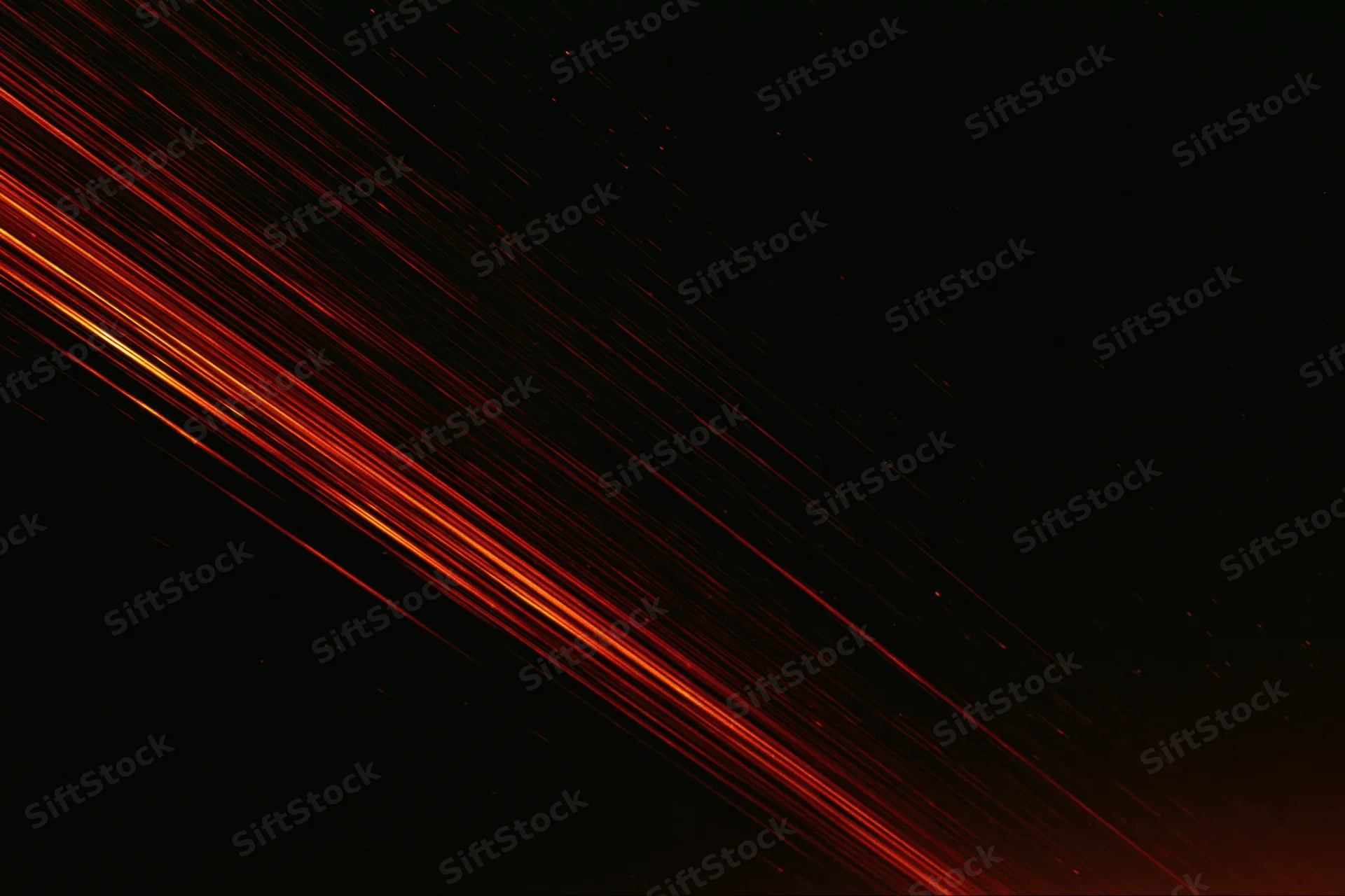 Long-exposure night sky with diagonal streaks of red and orange light from meteors