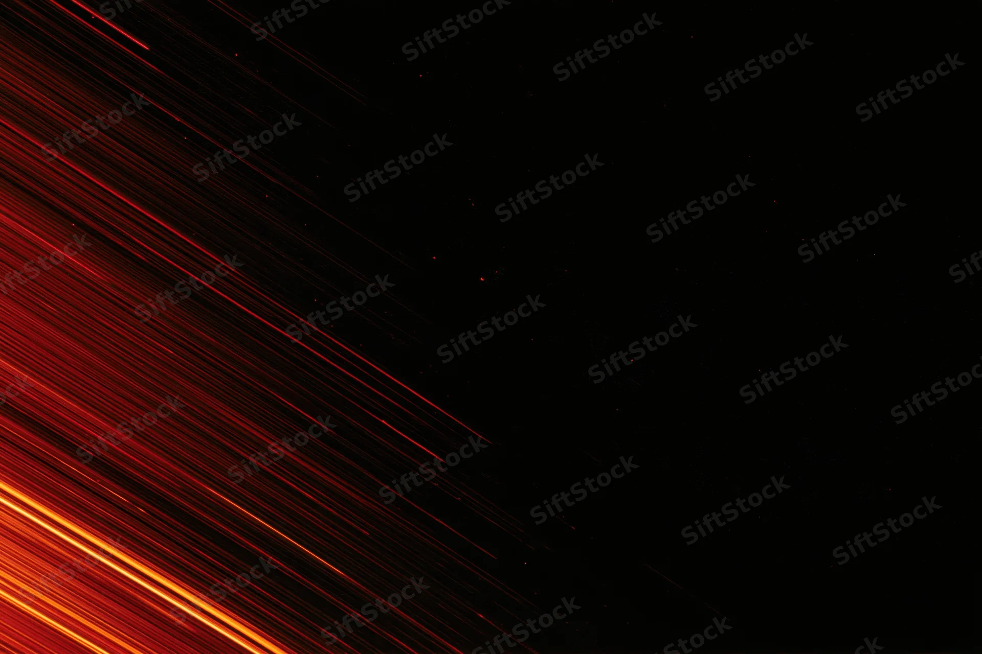 Long-exposure night sky with streaking red and orange meteor trails across dark space