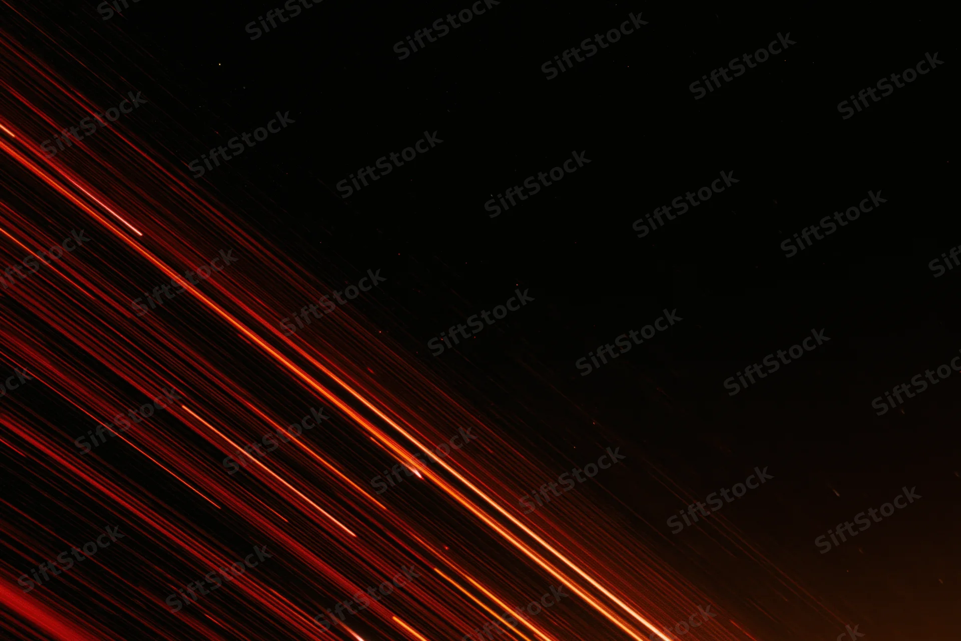 Long-exposure night sky with streaking red and orange meteor trails across dark space