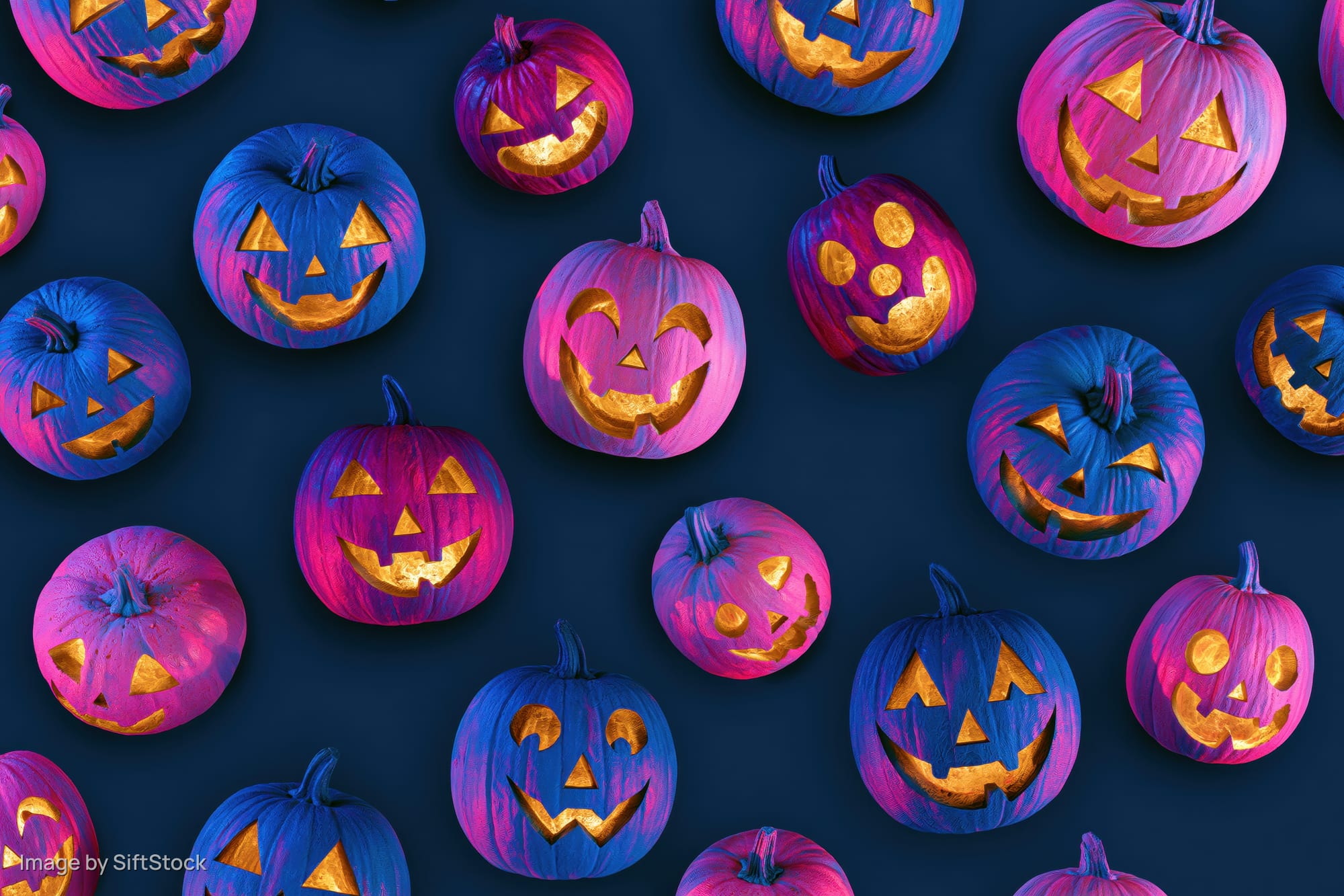 Carved jack-o-lantern pumpkins in blue and purple hues arranged in a repeating pattern on a dark background
