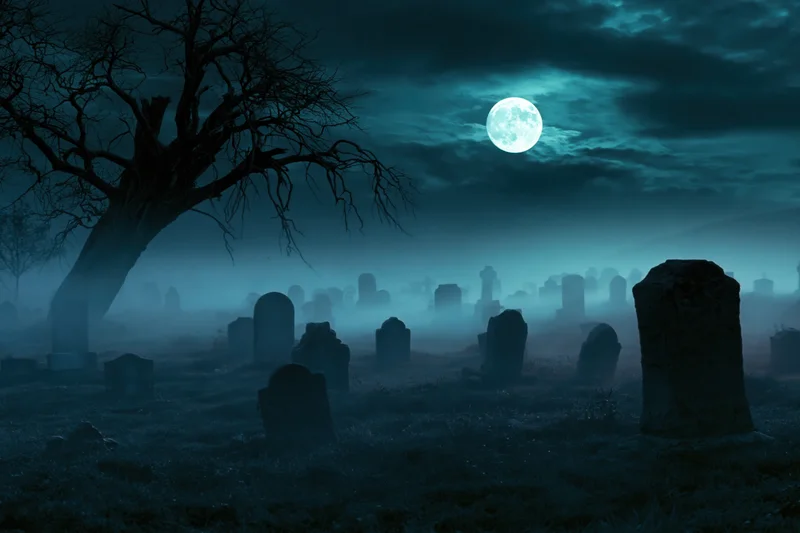 Old cemetery at night with scattered weathered gravestones under a full moon and fog