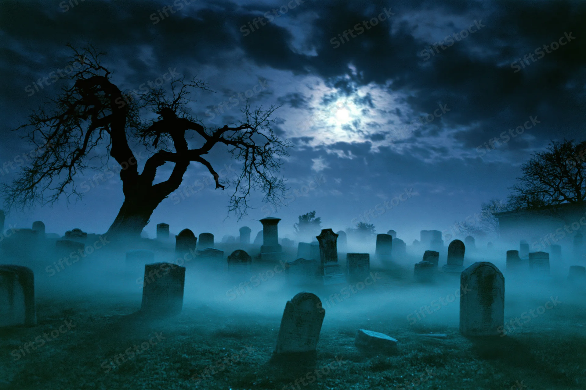 Foggy old cemetery at night with weathered gravestones and bare trees under a full moon