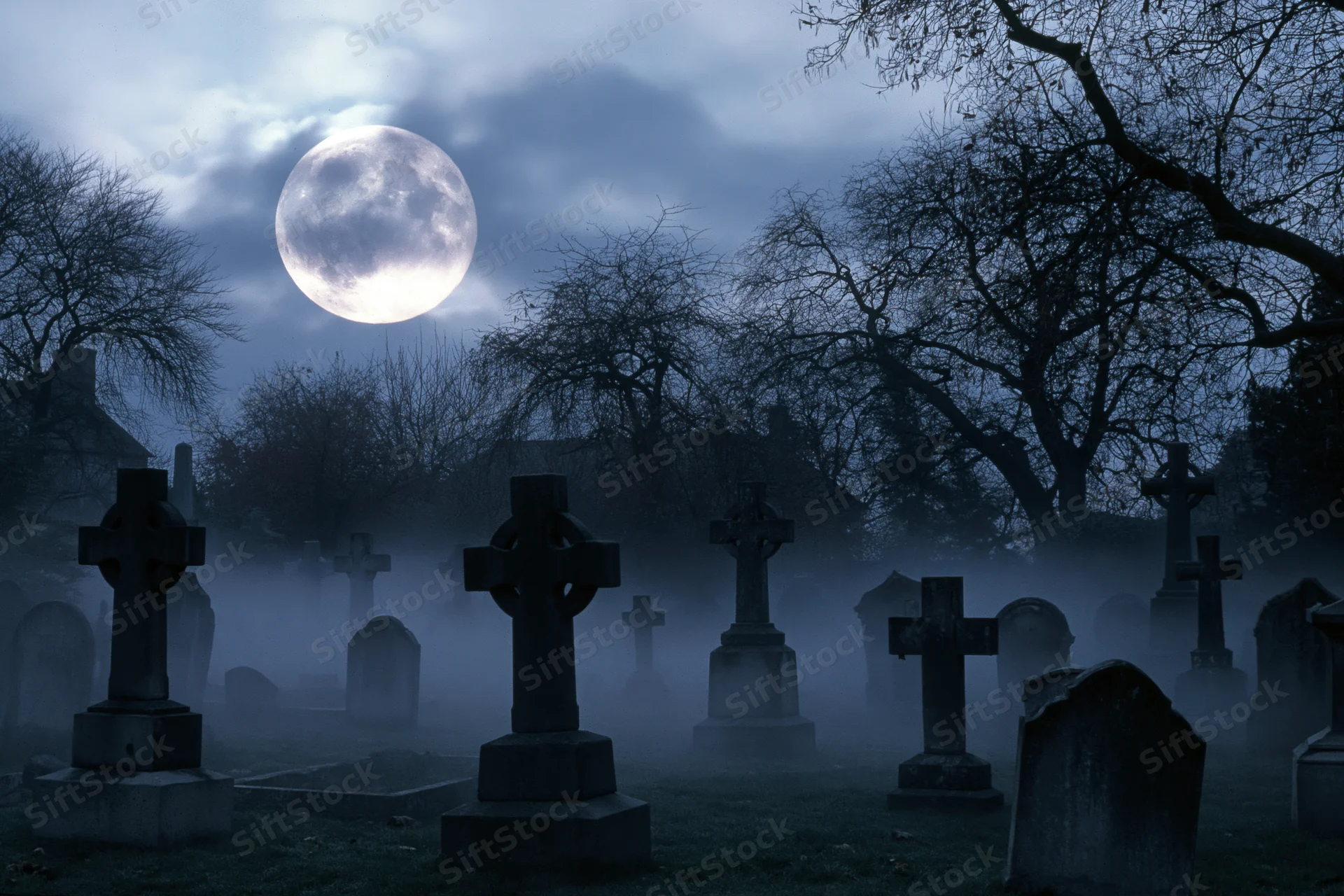 Foggy old cemetery at night with stone crosses and tombstones under a full moon