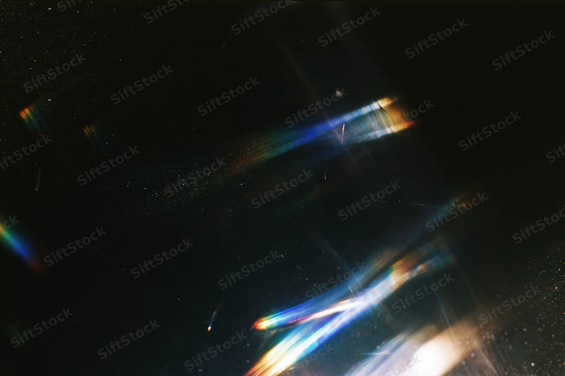 Colorful light streaks and lens flares scattered across a dark background