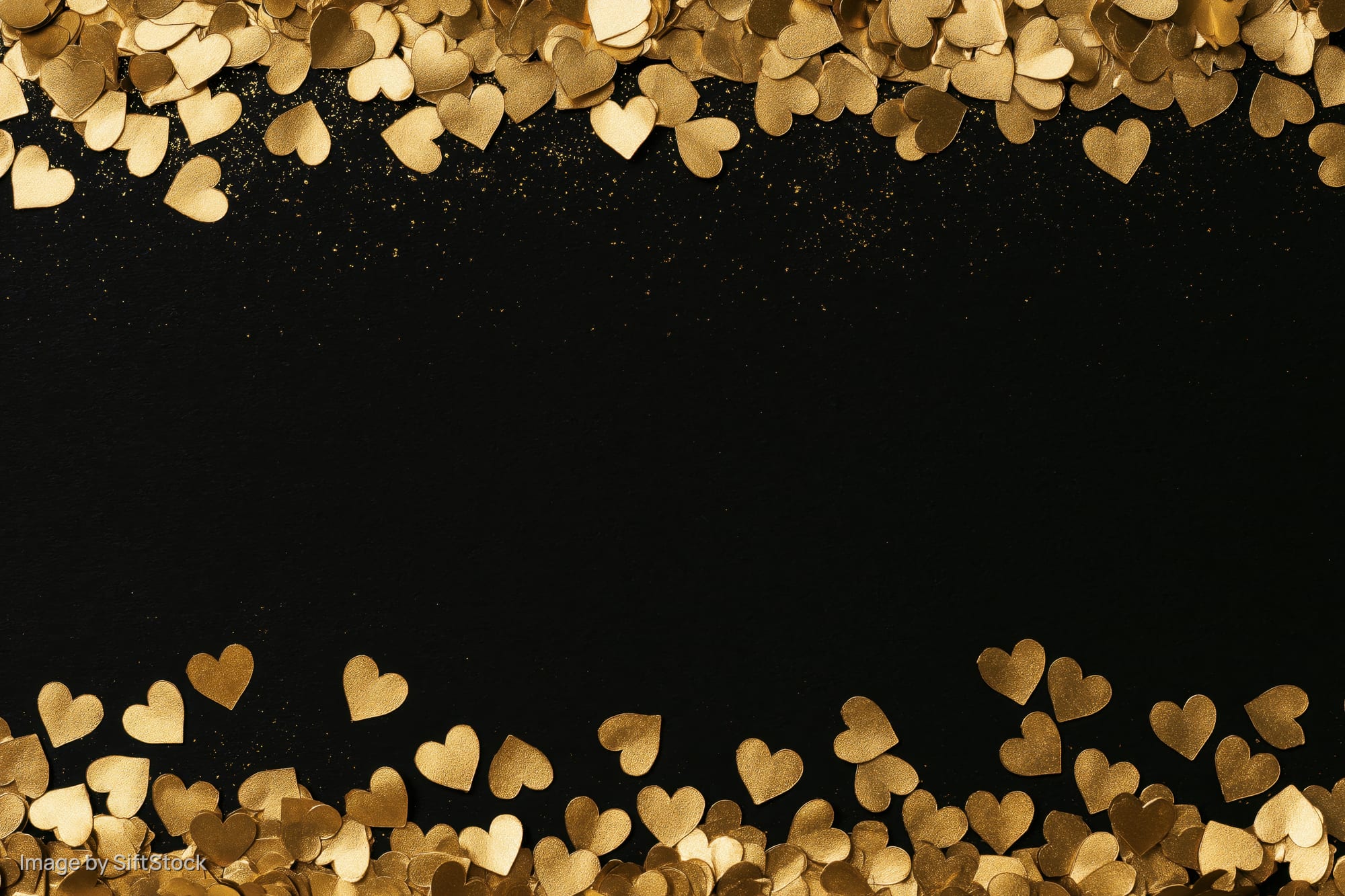 Gold metallic heart confetti arranged along top and bottom edges on black background with central copyspace