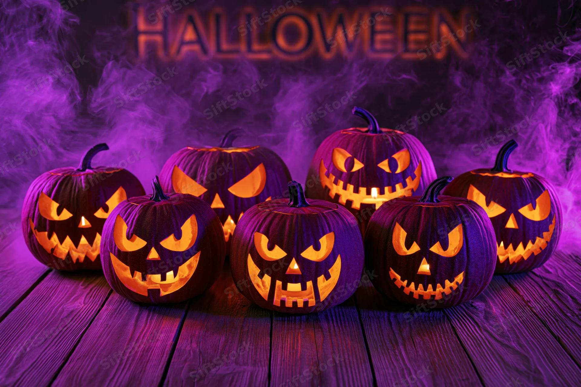 Seven carved jack-o-lanterns glowing with candlelight on a wooden table in purple smoke