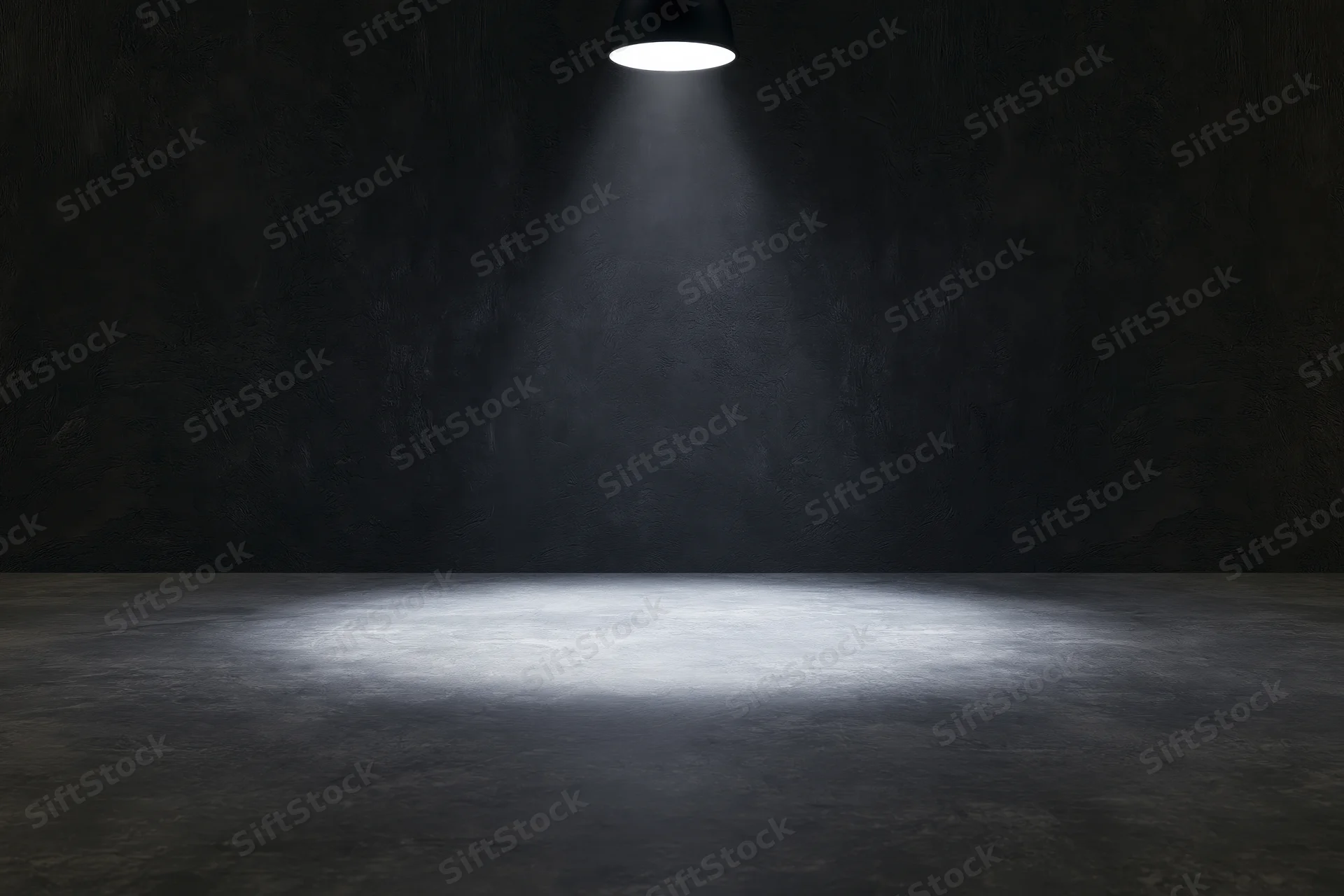 Single overhead spotlight casting a narrow cone of white light on a dark concrete floor and wall in an empty industrial room