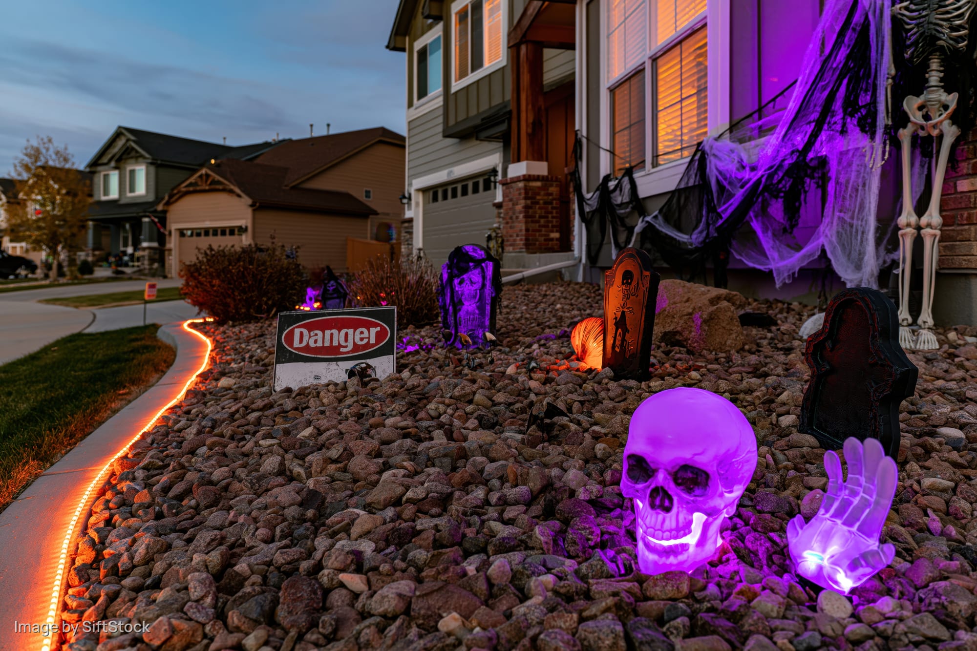 Halloween decorations glowing in a suburban front yard at night