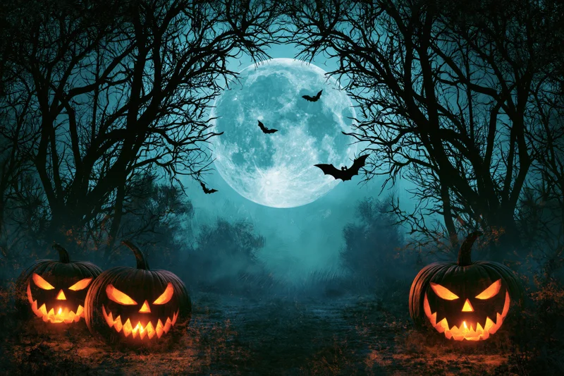 Three carved jack-o-lanterns glowing on a forest path under a full moon