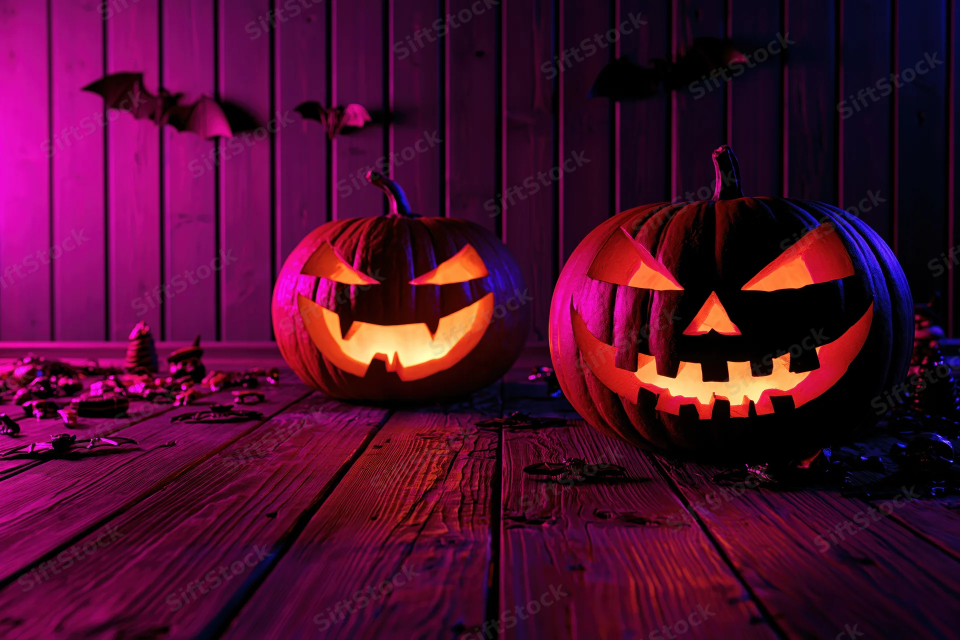Two carved jack-o-lanterns glowing on a wooden floor against a purple-lit wall with bat decorations