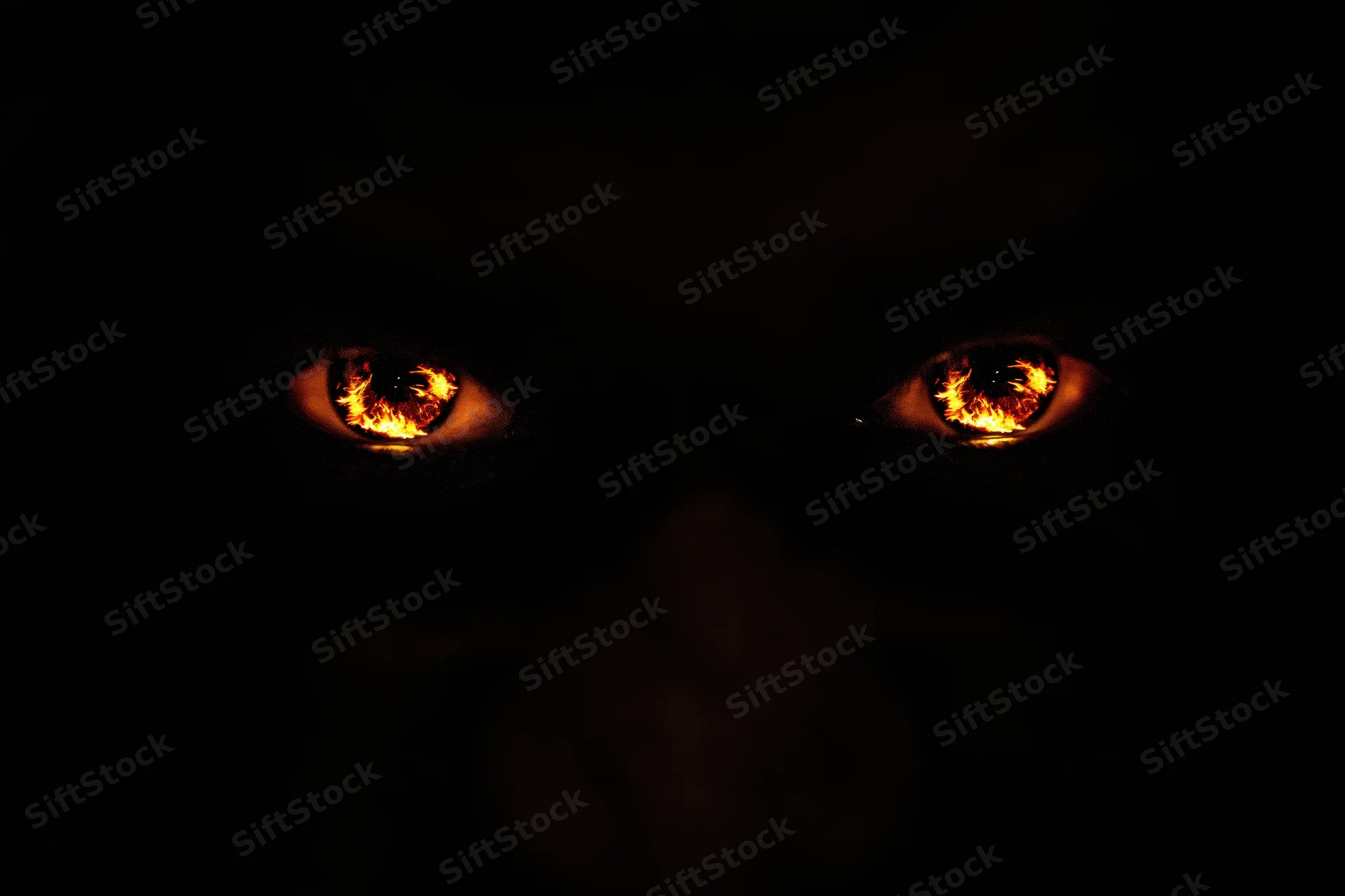 Glowing amber-orange eyes reflecting flames in darkness