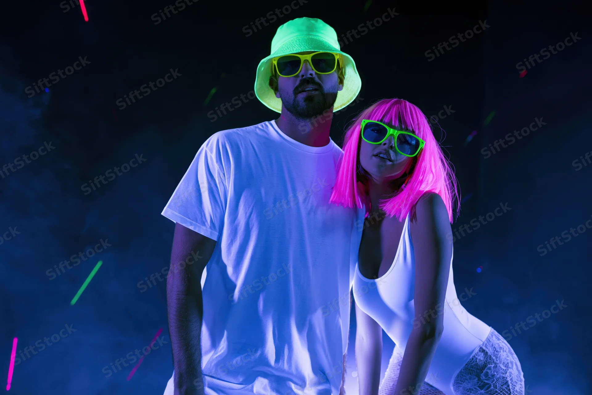 Couple posing together under uv blacklight in a nightclub with neon glow and smoke