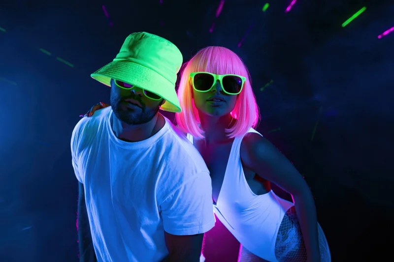 Couple posing together under uv blacklight in a nightclub