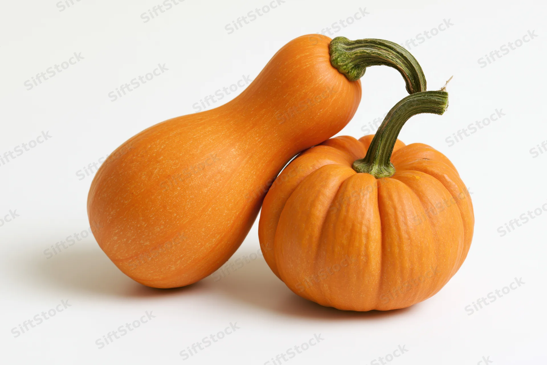 Two small orange pumpkins side by side on a white background