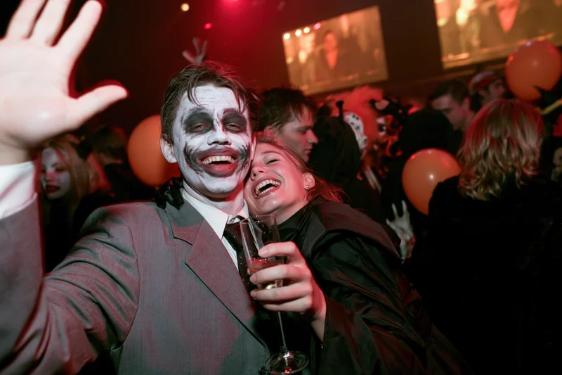 Young couple in halloween costumes dancing and laughing at a nightclub party