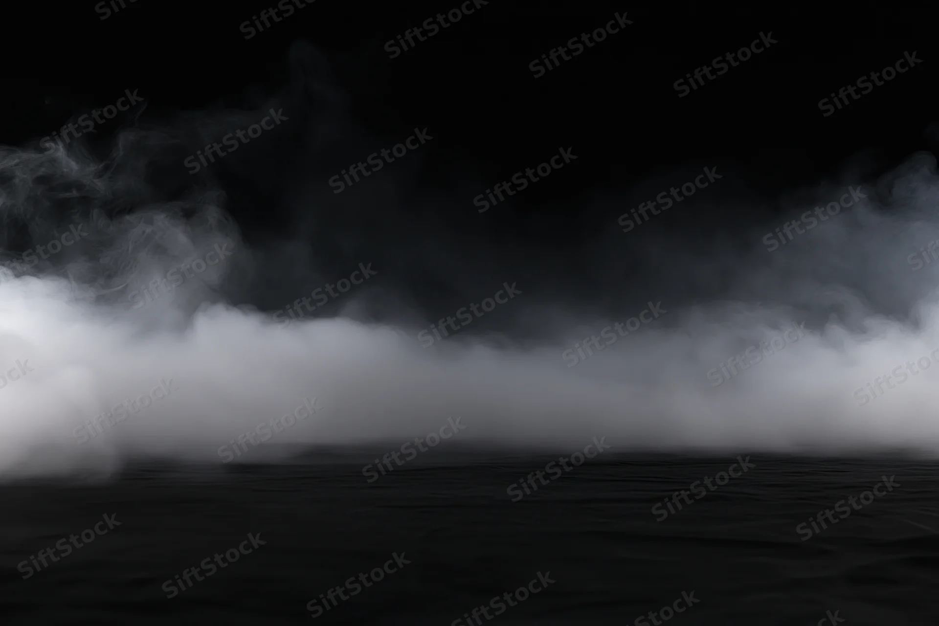 White smoke spreading low across a dark studio floor