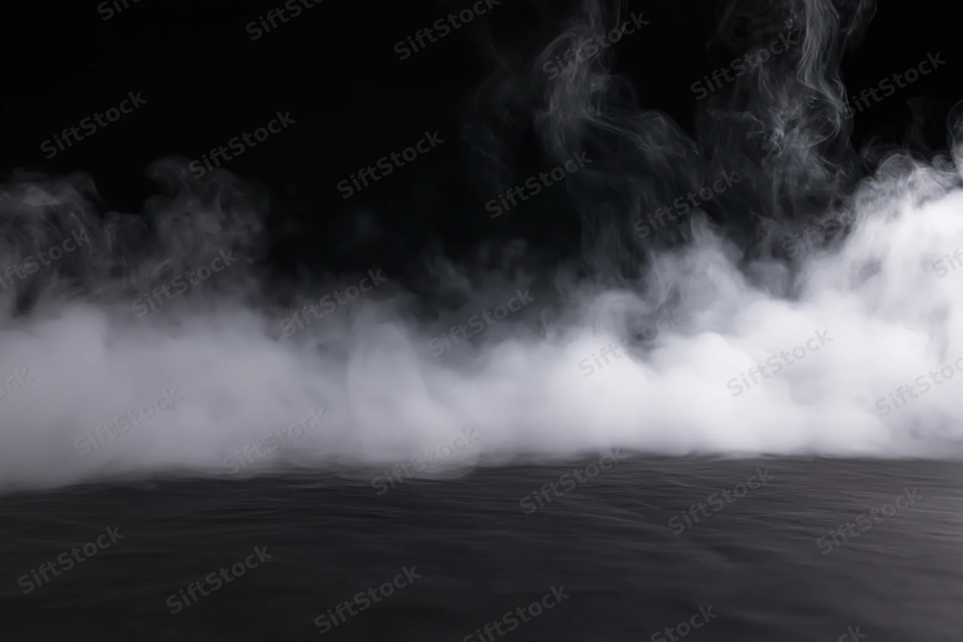 White smoke rising from a dark studio floor