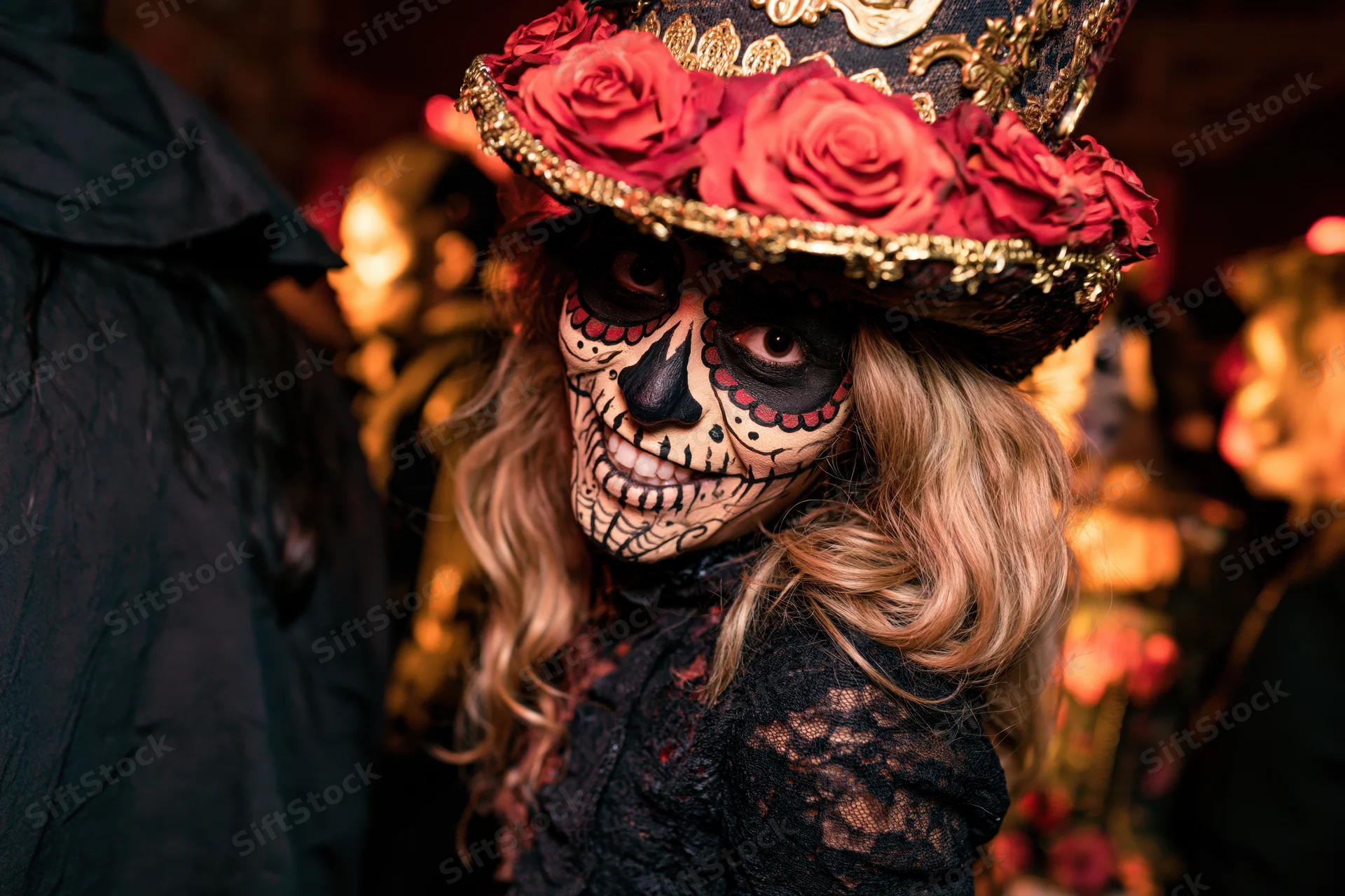 Woman with sugar skull face paint and floral hat at a Day of the Dead celebration