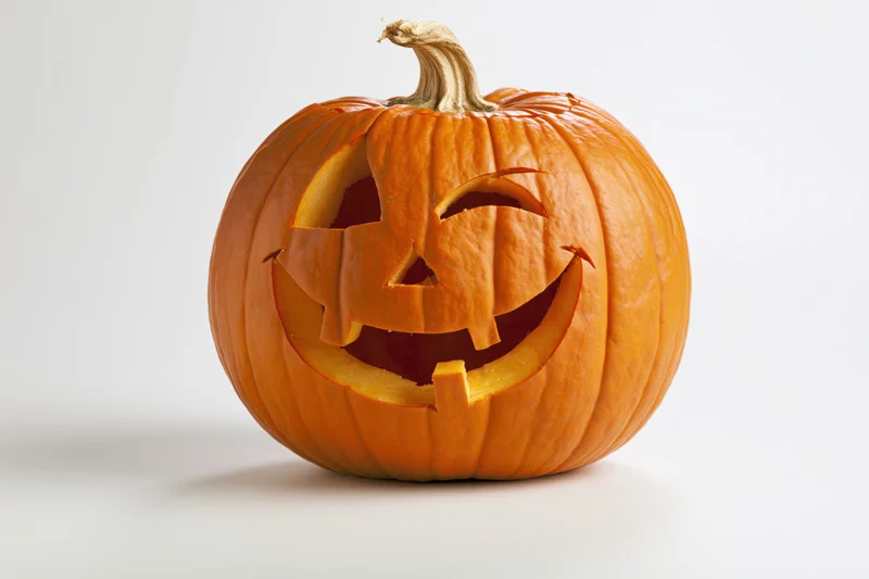 Carved pumpkin with smiling face on white background