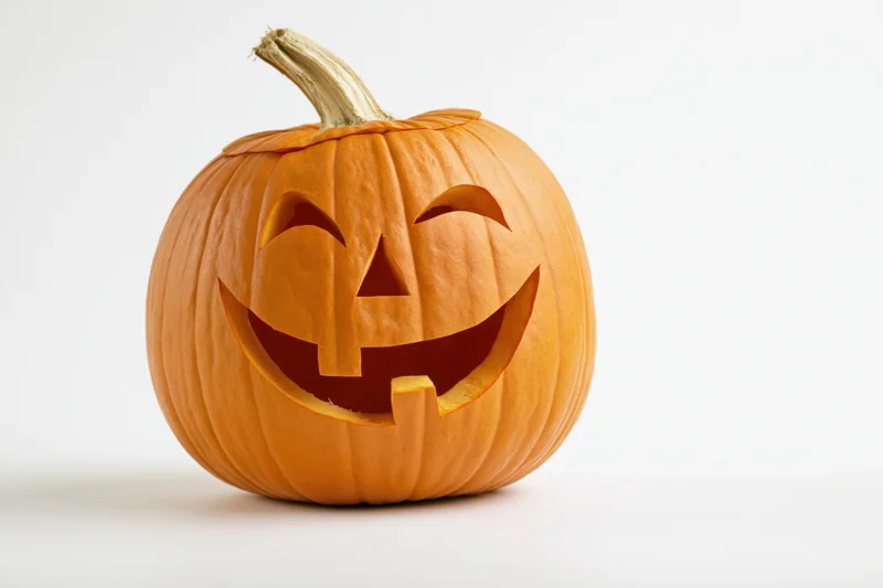 Carved pumpkin with smiling face on white background