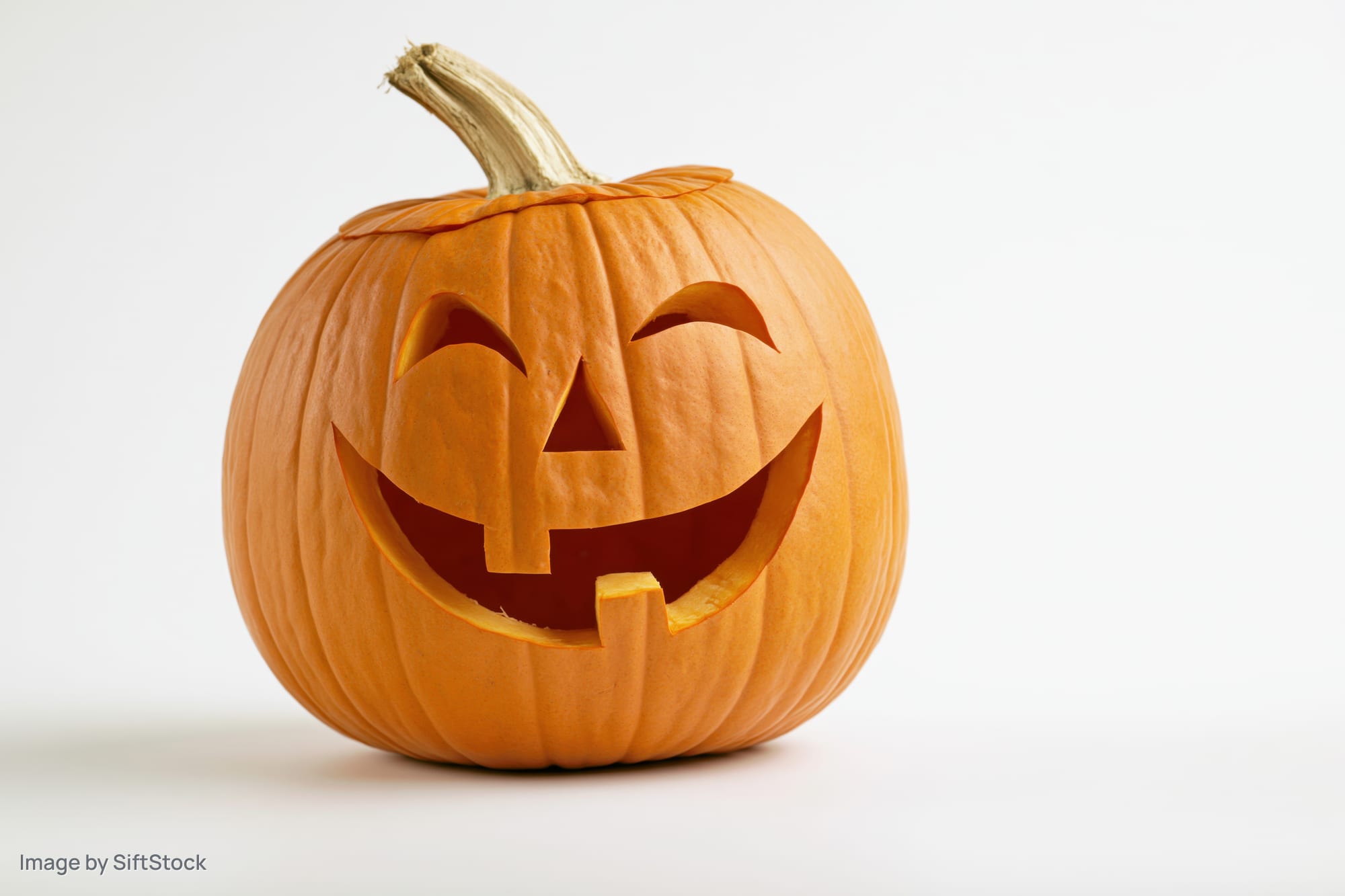 Carved pumpkin with smiling face on white background