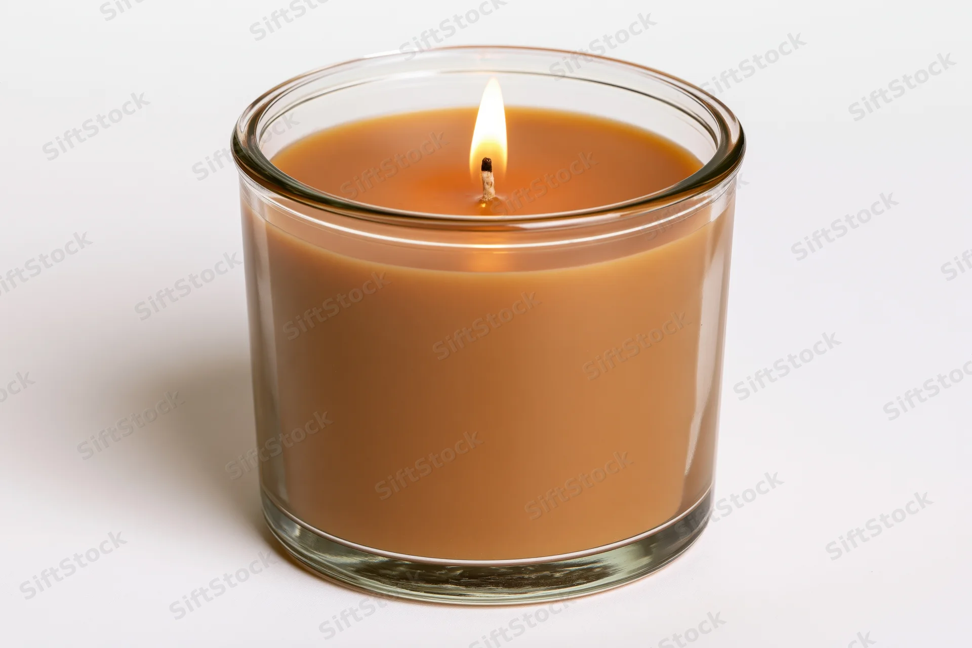 Lit soy candle in clear glass jar on white background