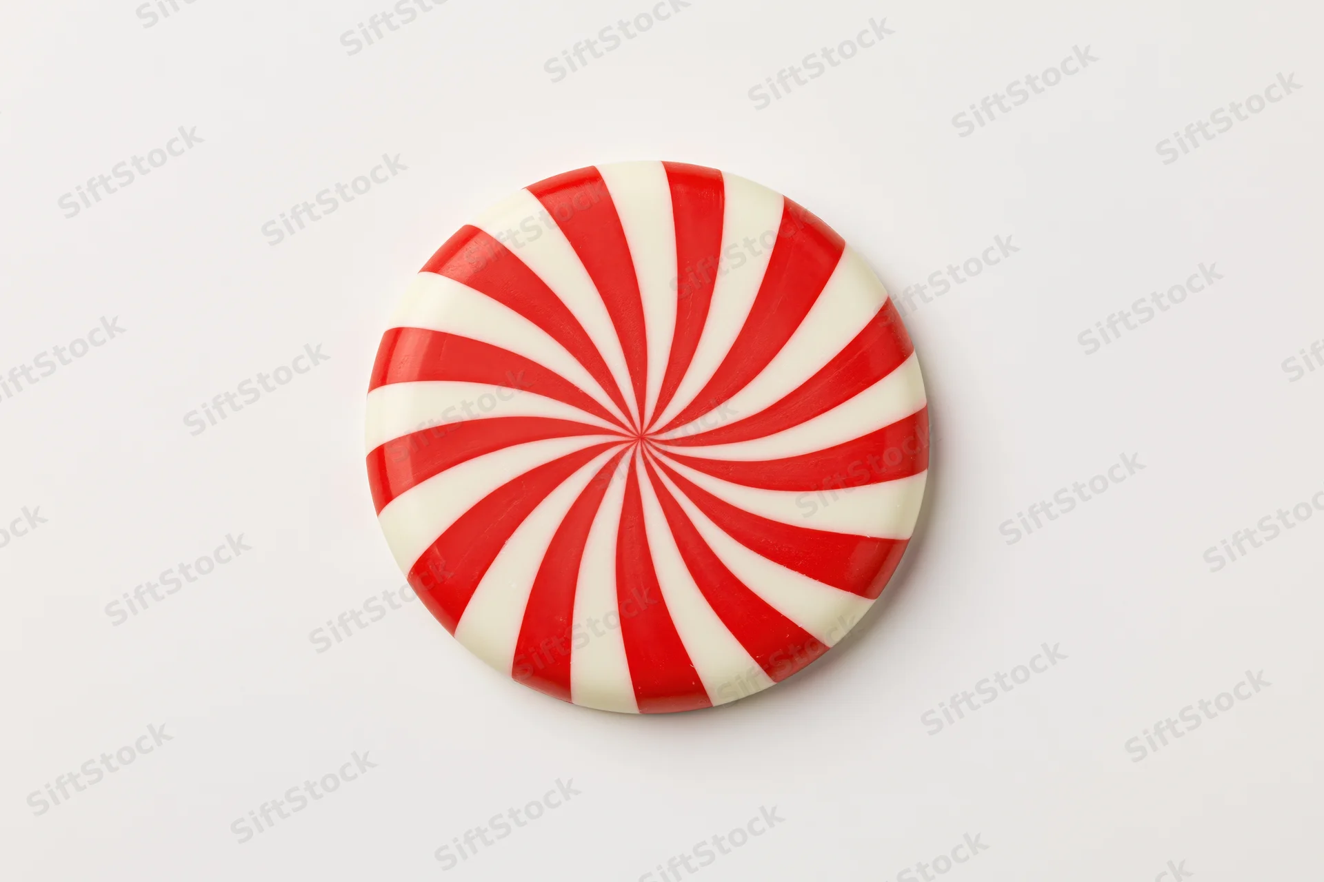 Round peppermint candy disc with red and white swirl pattern on white background