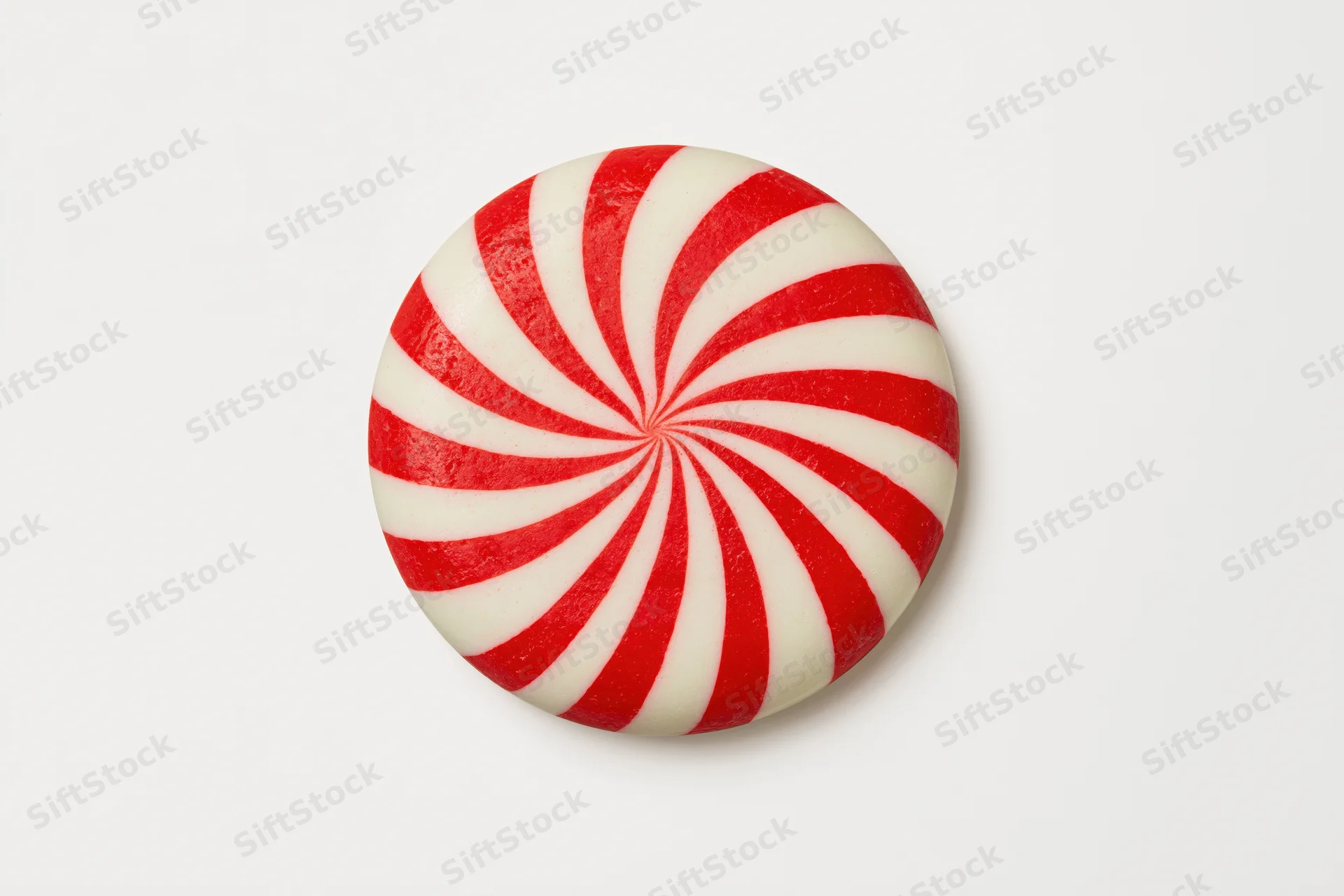 Round peppermint candy disc with red and white swirls on white background