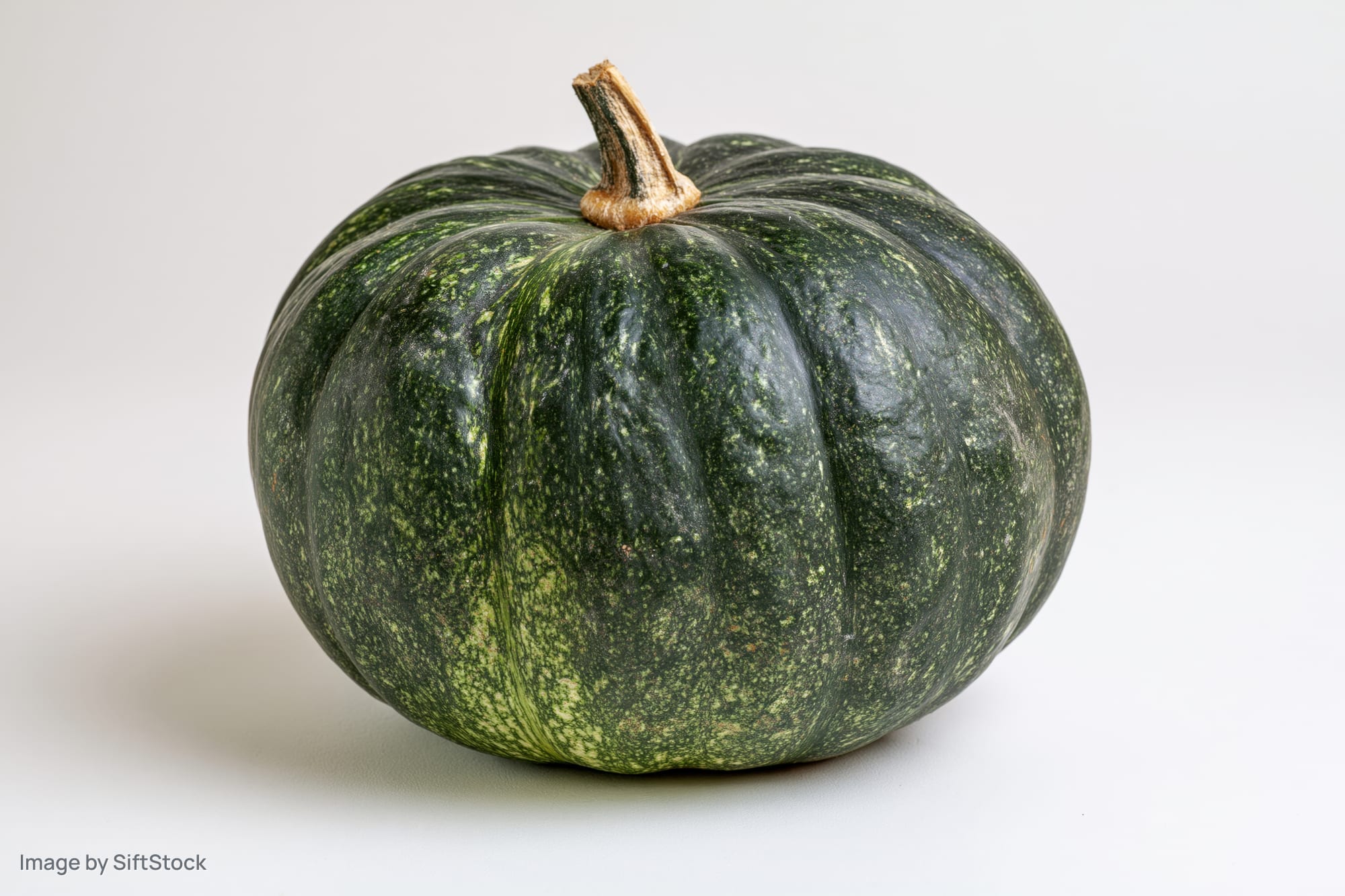 Kabocha squash resting on a white surface