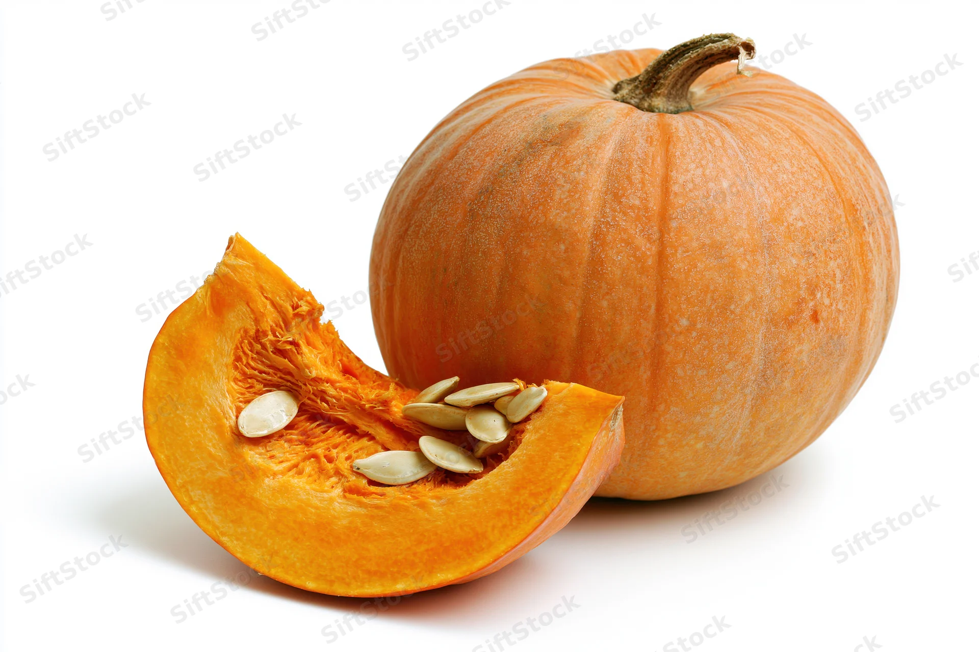 Whole pumpkin with a cut slice in front on white background