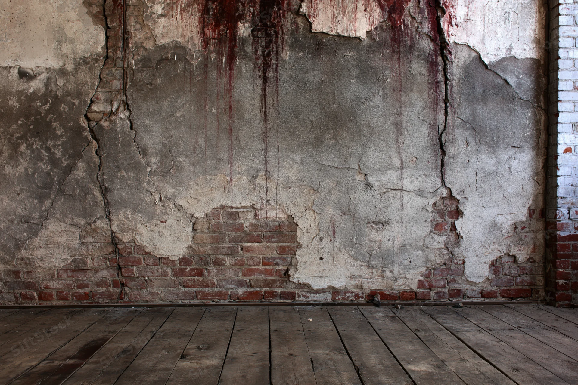 Damaged concrete and exposed brick wall in an abandoned room with wooden floor