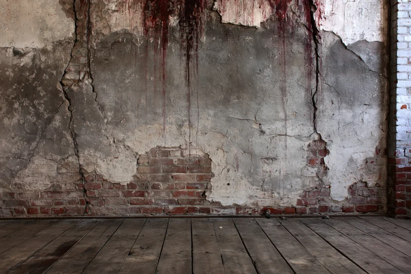 Damaged concrete and exposed brick wall in an abandoned room with wooden floor