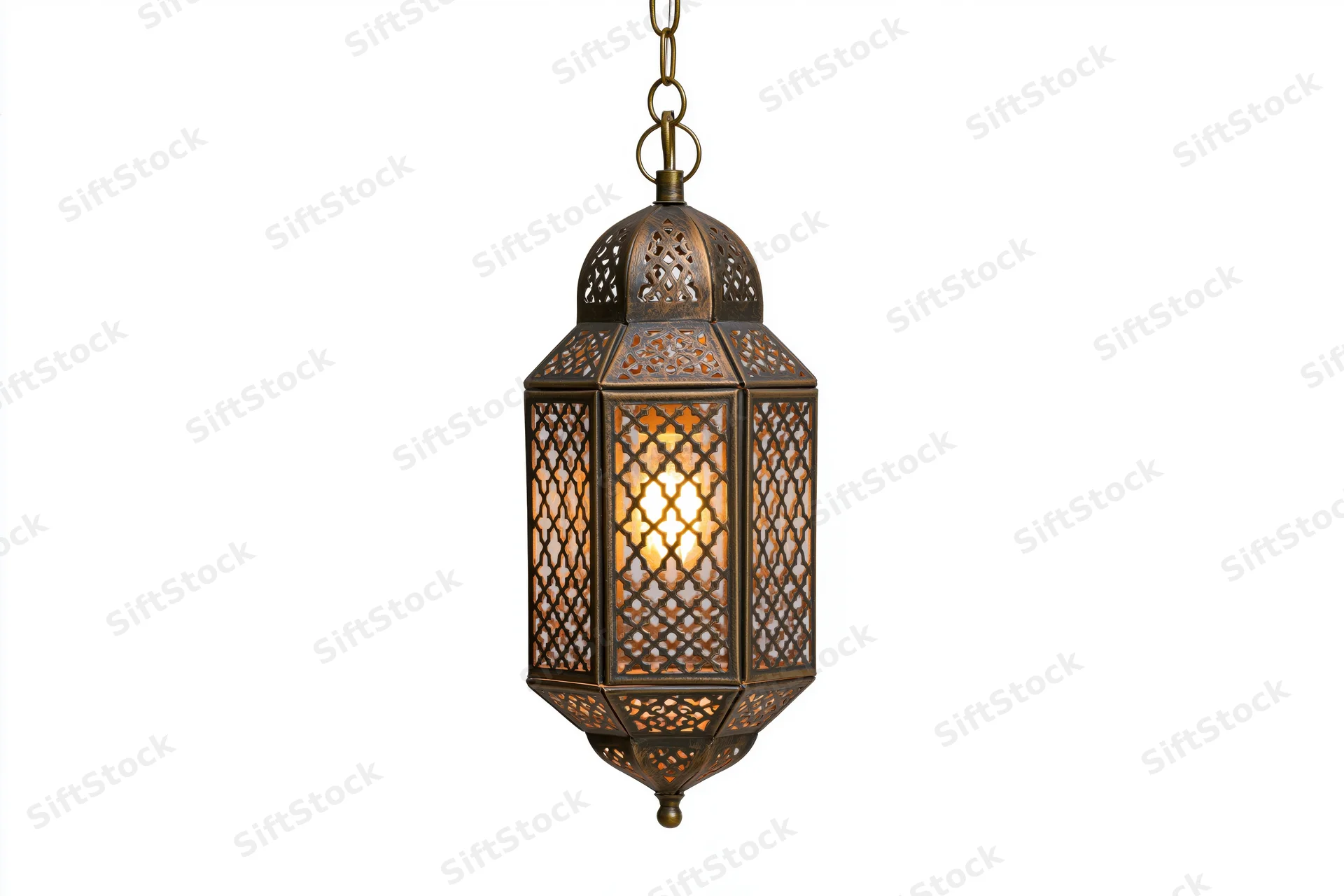 Antique moroccan lantern hanging from a brass chain with intricate cutout patterns glowing warmly against white background