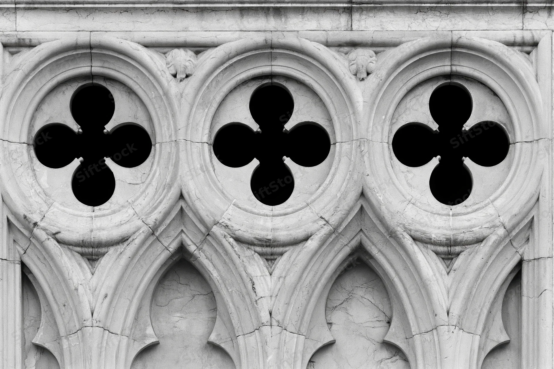 Close-up of gothic stone tracery with quatrefoil patterns on a cathedral facade