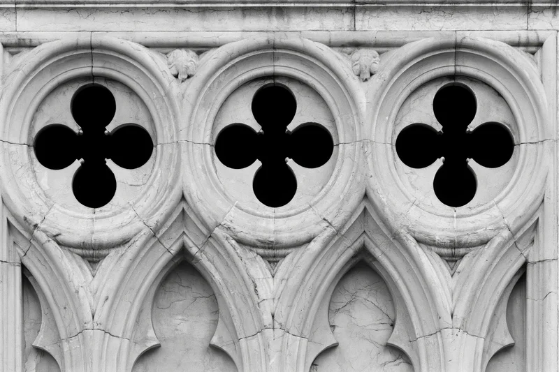 Close-up of gothic stone tracery with quatrefoil patterns on a cathedral facade