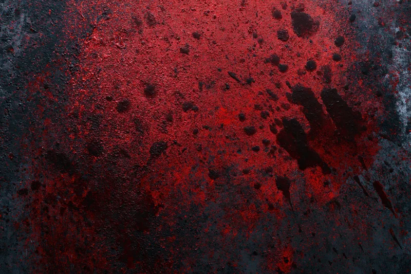 Red handprint and splatters on dark textured surface