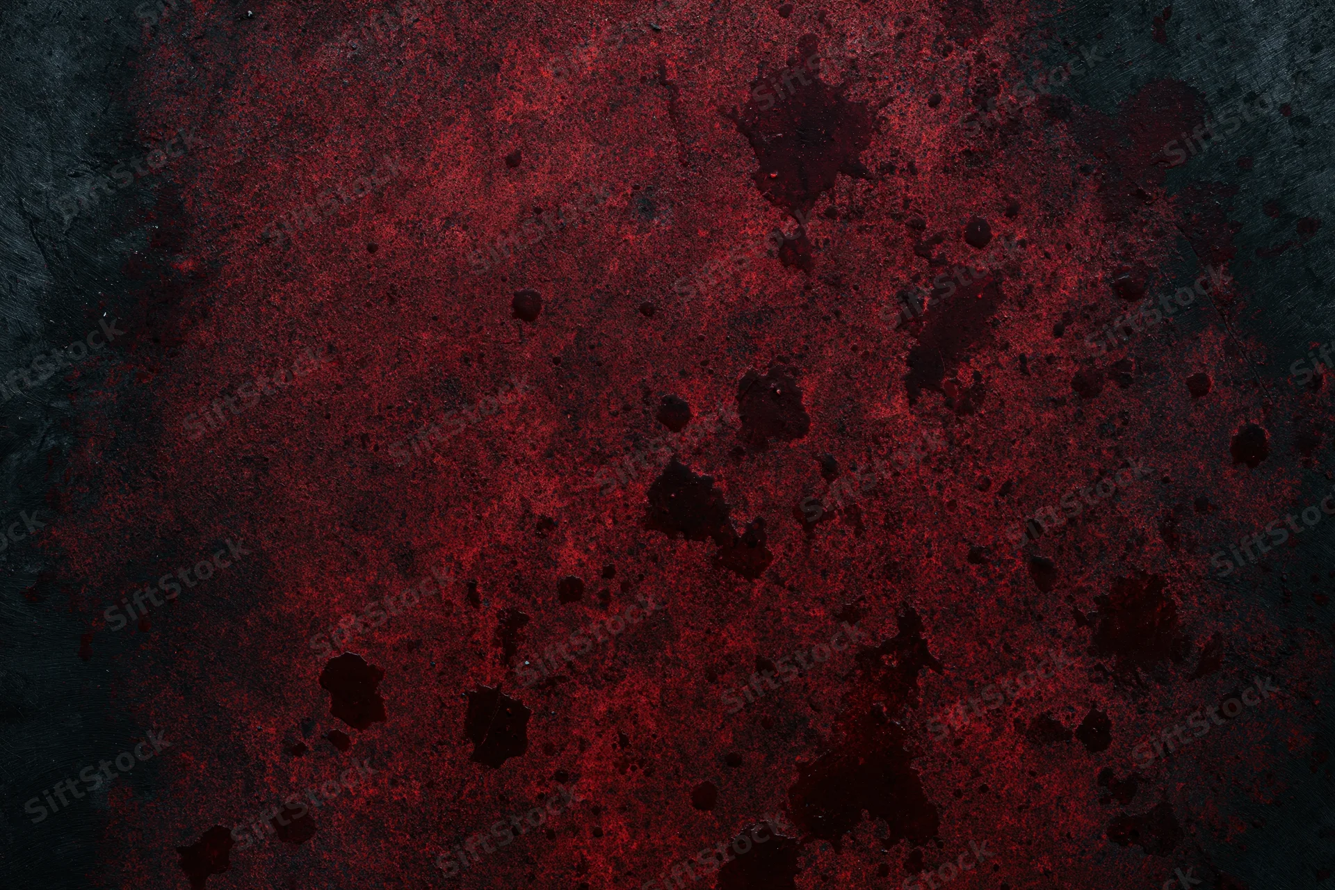 Abstract red splatters on a dark rough surface