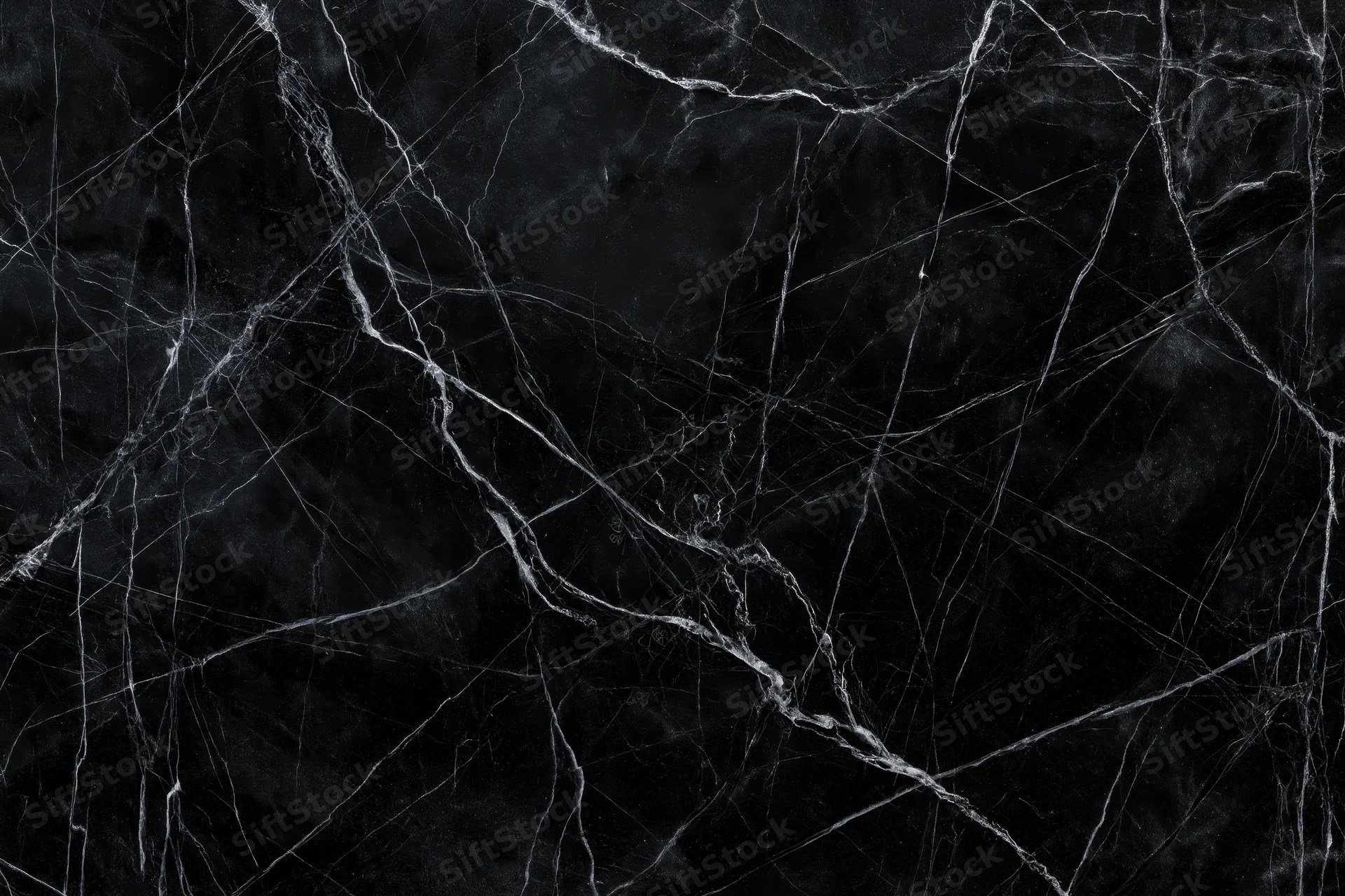 Close-up of polished black marble surface with white veining pattern
