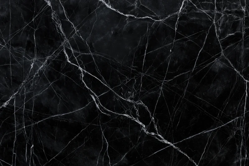 Close-up of polished black marble surface with white veining pattern