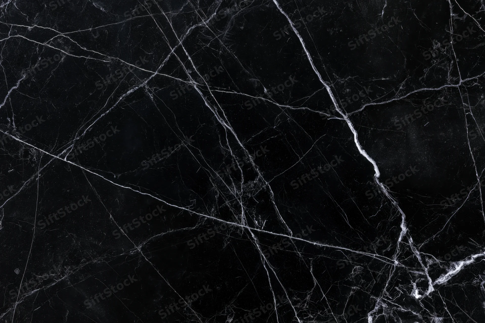 Close-up of polished black marble surface with white veining pattern
