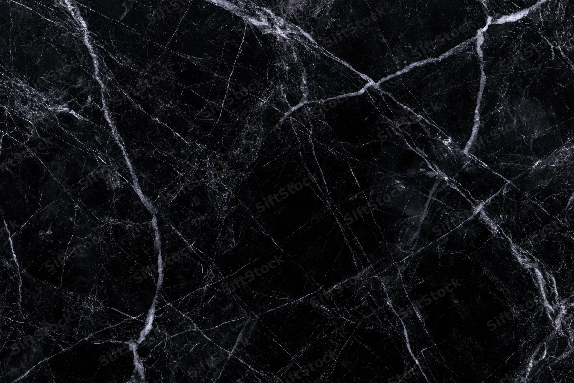 Close-up of polished black marble surface with white veining pattern