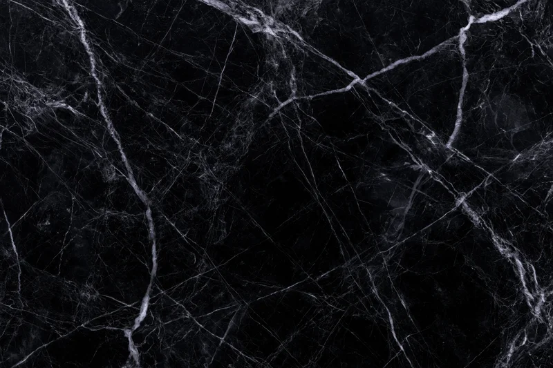 Close-up of polished black marble surface with white veining pattern